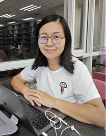 A person sitting at a table with a computerDescription automatically generated